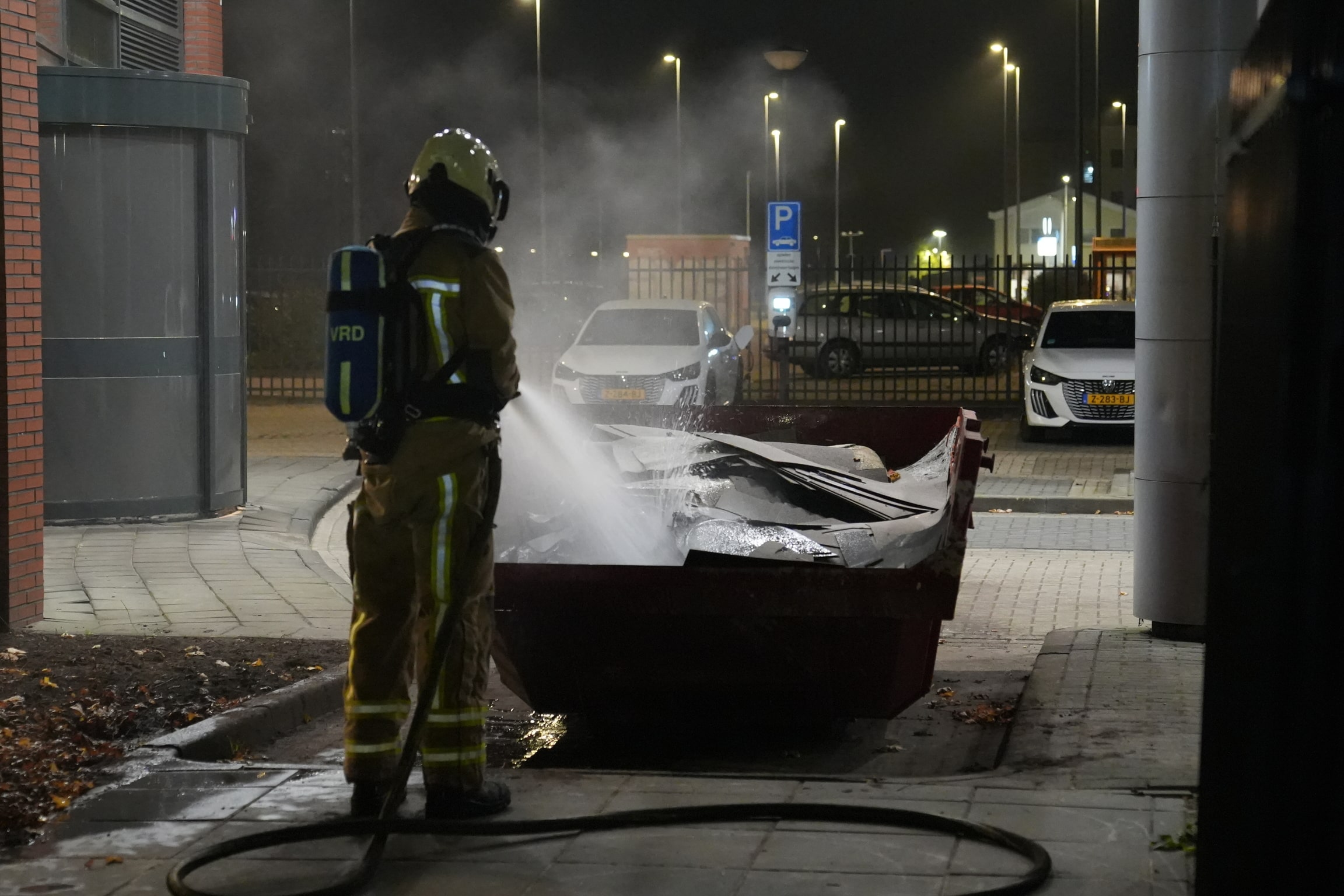 Brandweer blust brand in bouwcontainer