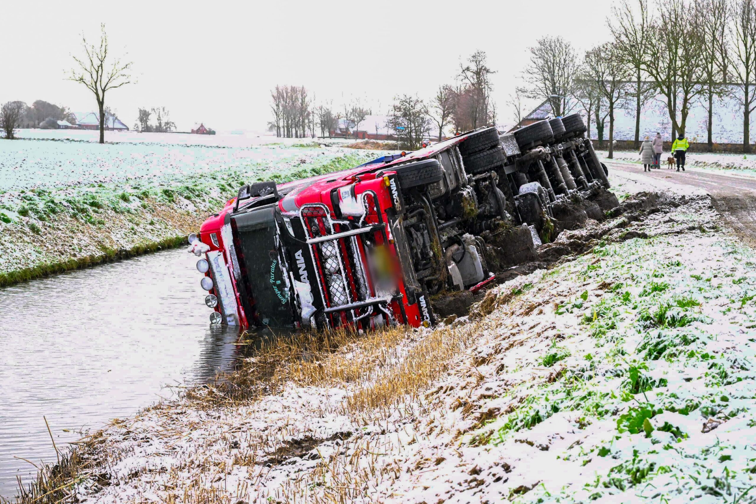 Vrachtwagen glijdt van de weg en komt in sloot terecht