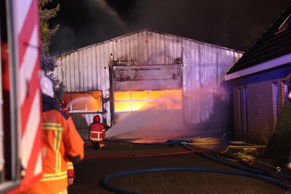 Loods in lichterlaaie achter woning, veel rookontwikkeling