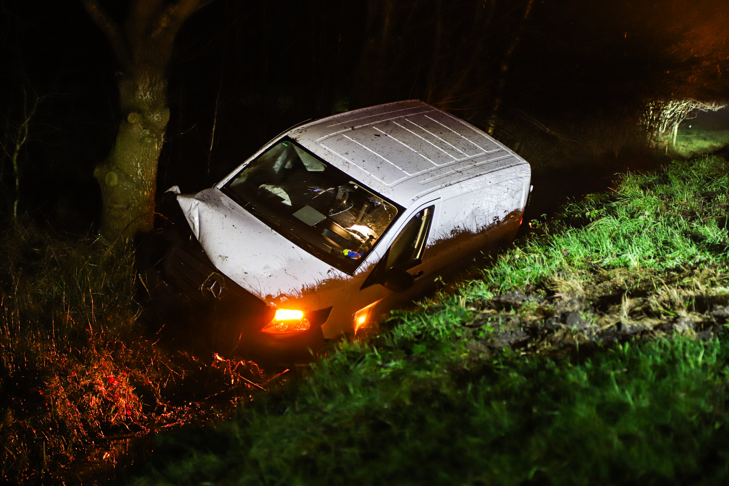 Bestelbus belandt in sloot, bestuurder lichtgewond