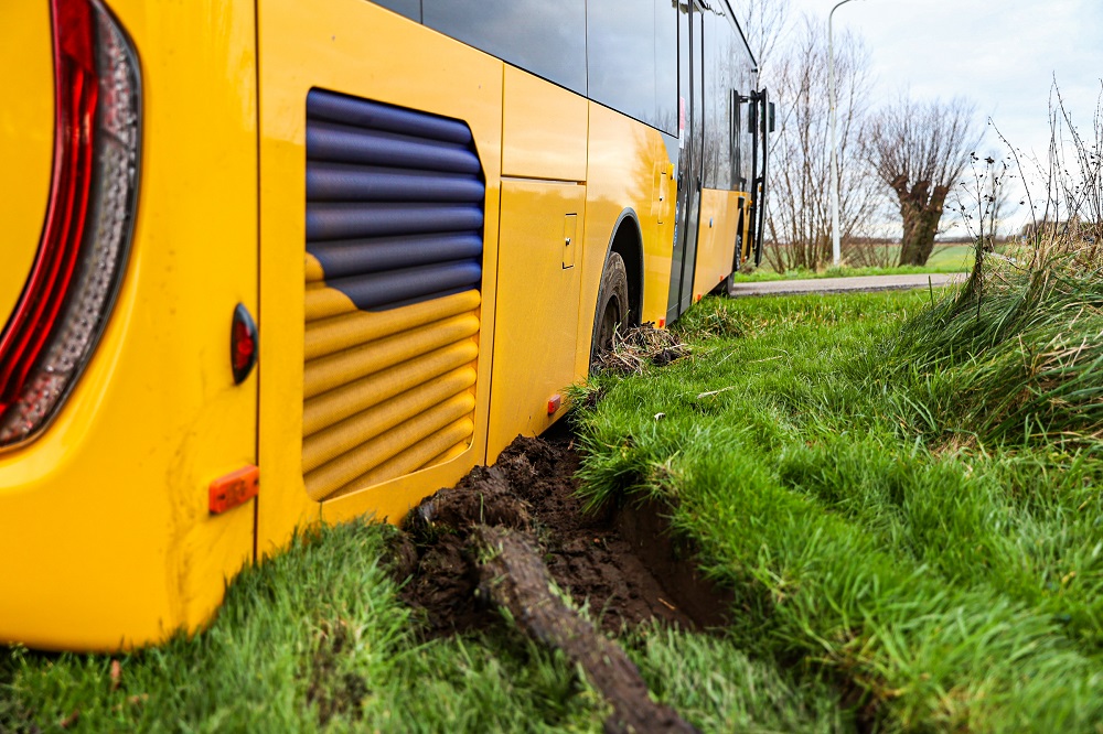 Lijnbus rijdt zich vast in berm en blokkeert de weg