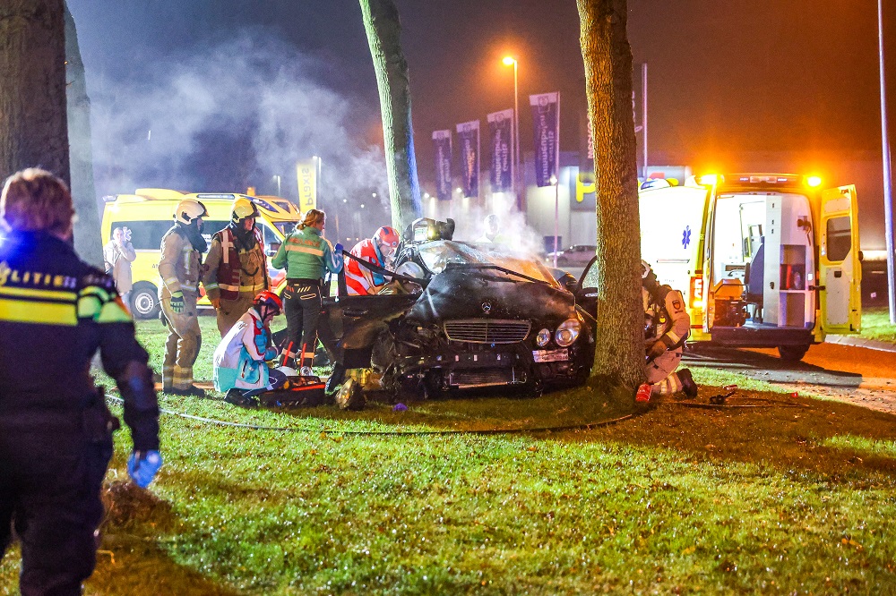 Auto botst tegen boom, één persoon bekneld