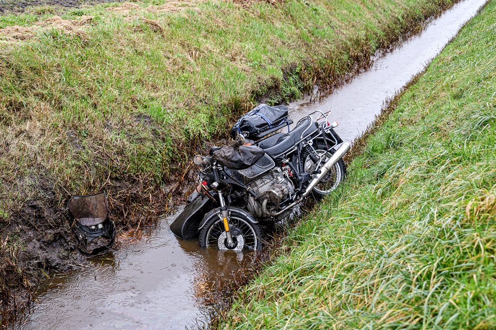 Motor met zijspan belandt in sloot, bestuurder gewond
