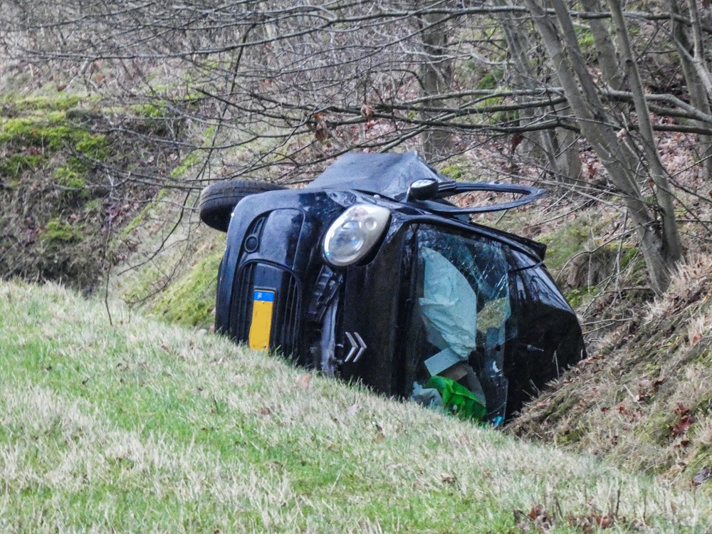 Auto in greppel na botsing met vrachtwagen, bestuurder ernstig gewond