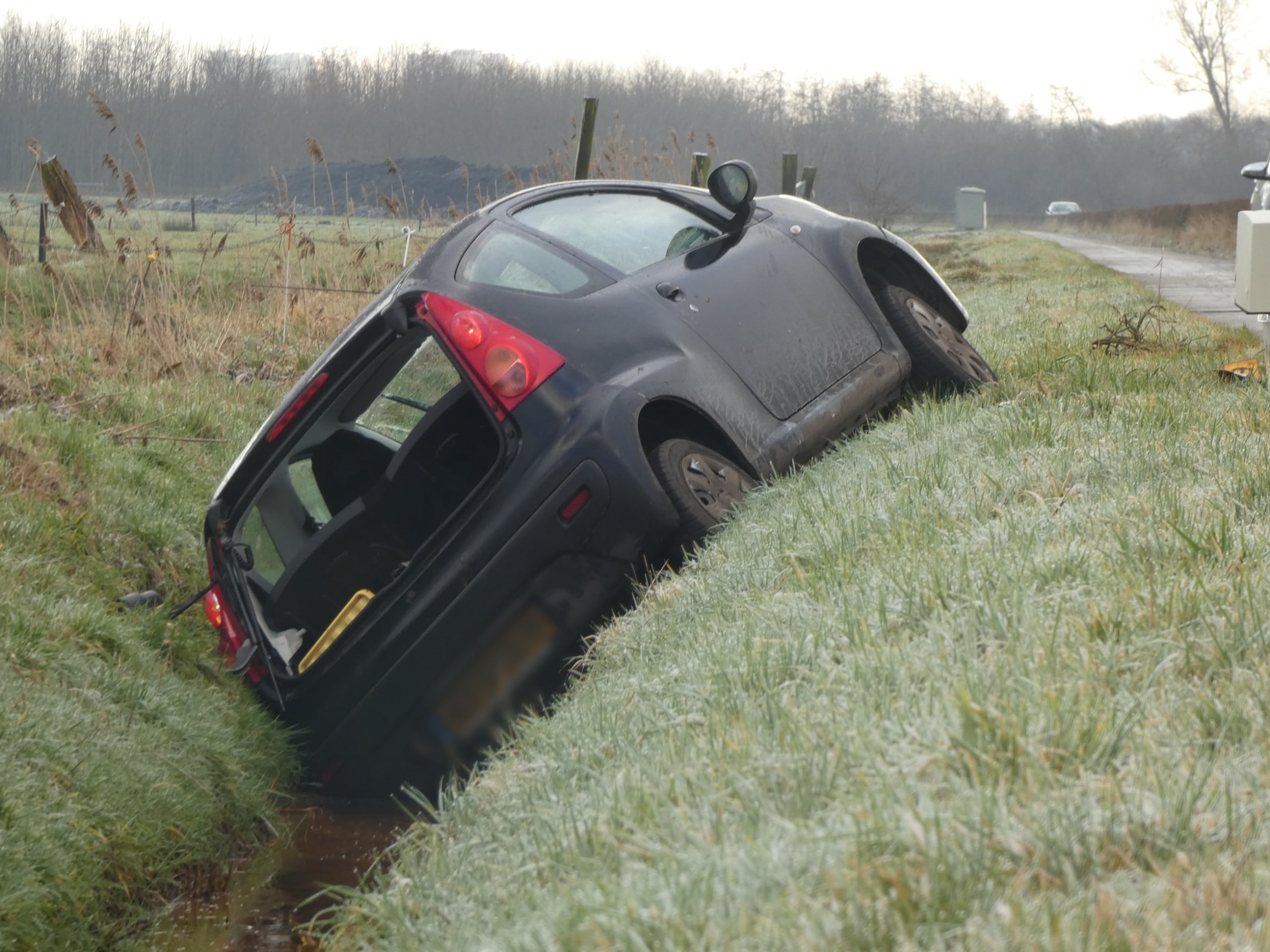 Auto glijdt van de weg en belandt in sloot