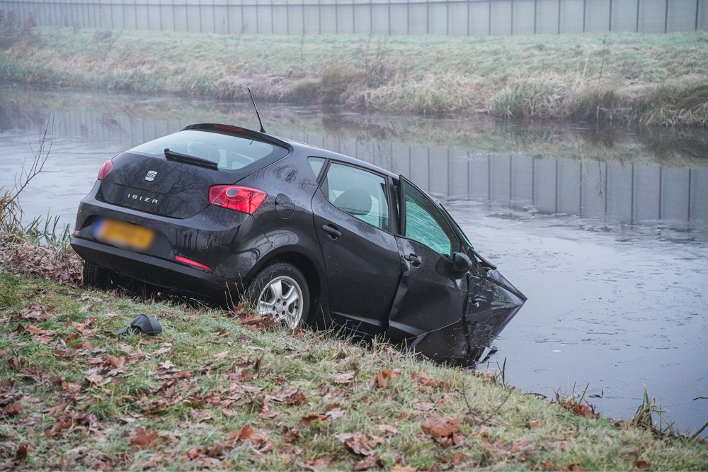 Auto belandt in kanaal na botsing tegen boom