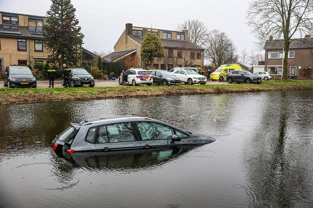 Auto rijdt vijver in, bestuurder kan zelf op het droge komen