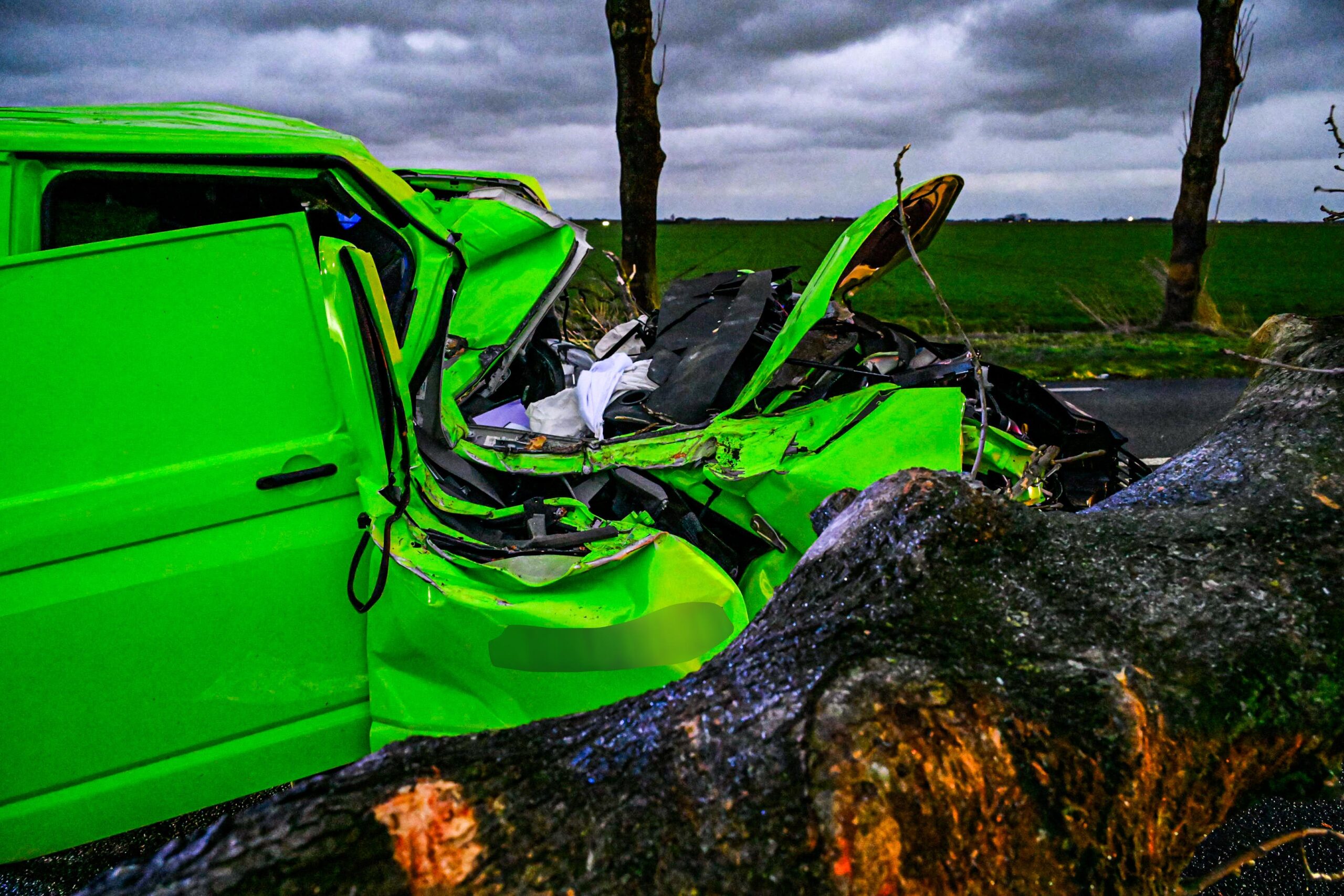Grote boom valt op rijdende auto, bestuurder bekneld
