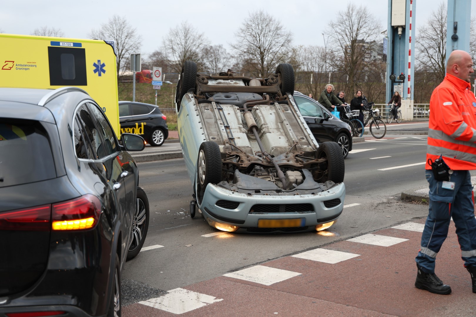 Auto op de kop beland na botsing, Hulpdiensten met spoed ter plaatsen