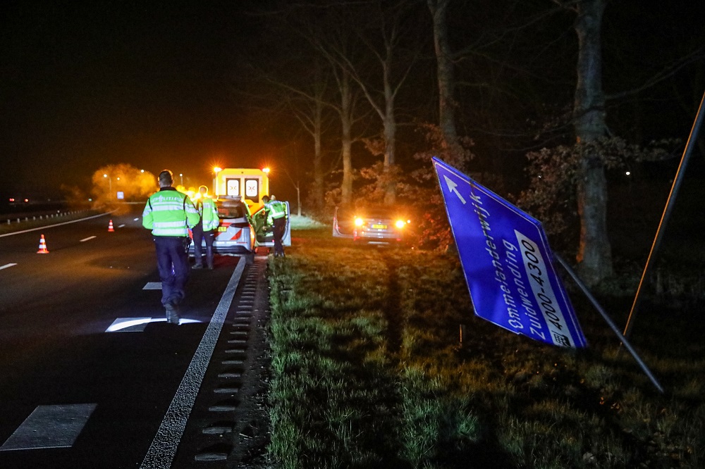 Auto ramt verkeersbord en boom, bestuurder gewond