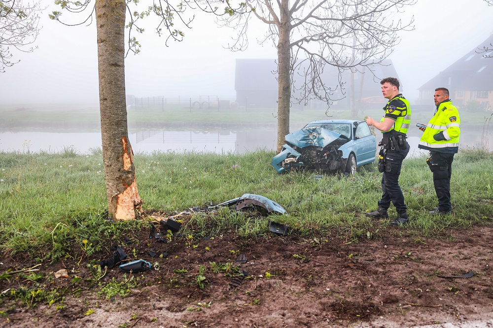 Automobilist bekneld na botsing tegen boom
