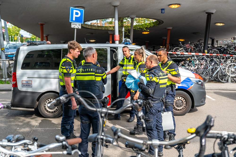 Agenten met getrokken wapens arresteren meerdere verdachten bij station