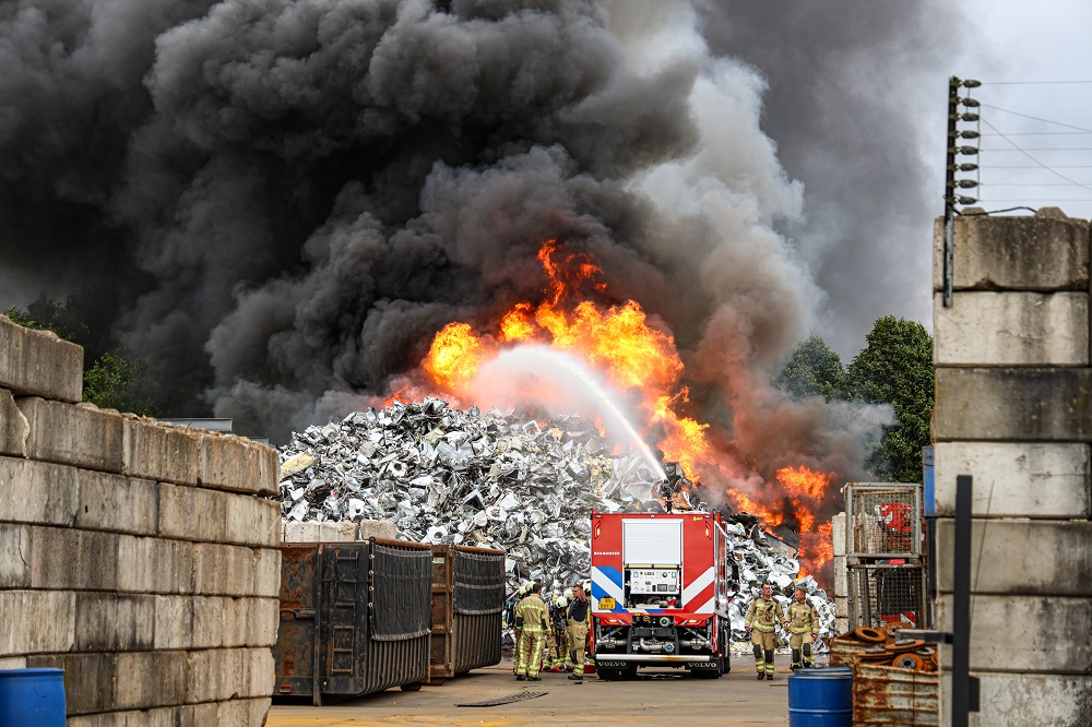 Zwarte rookwolk door grote brand in schroothoop bij ijzerhandel