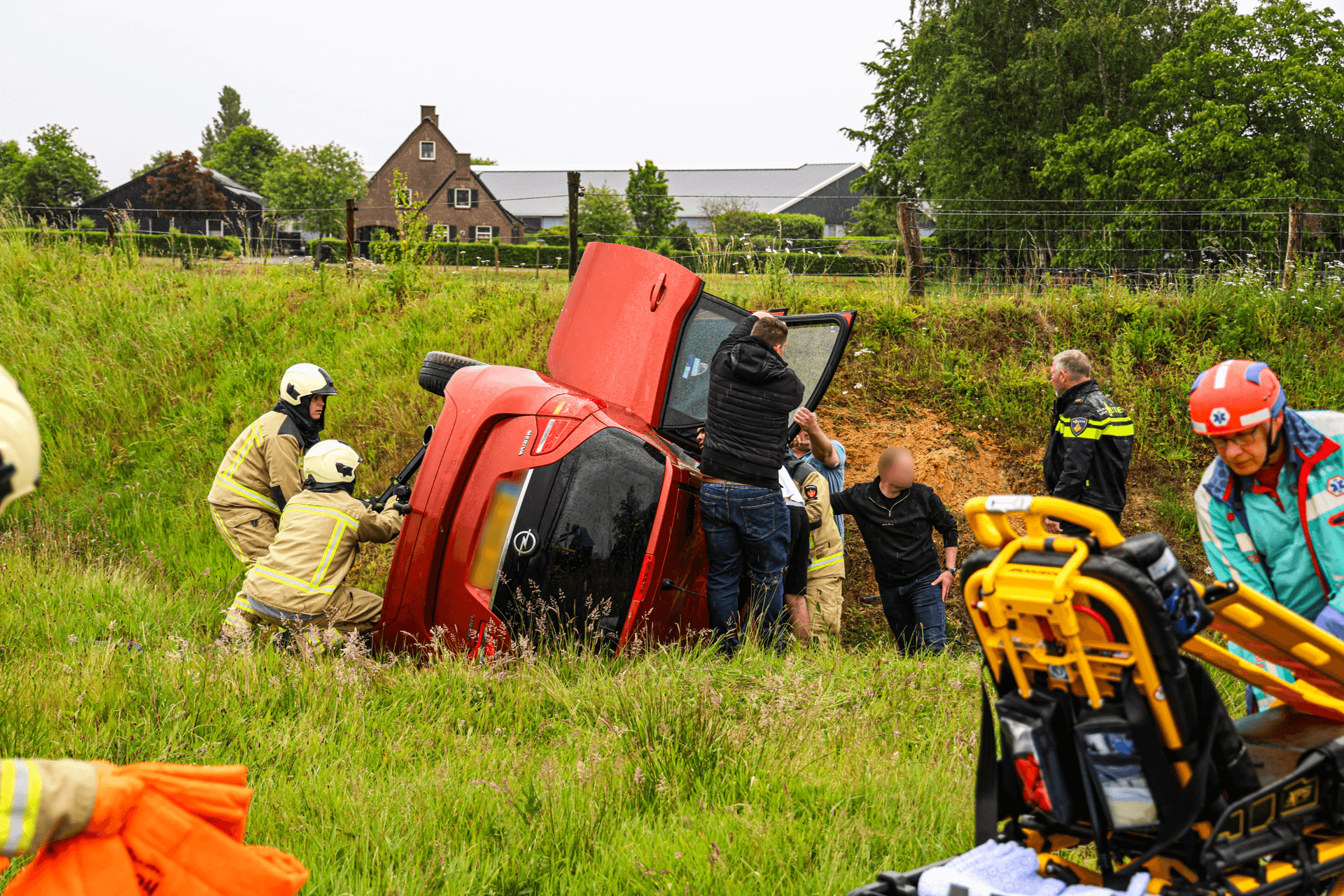 Auto belandt op zijkant na crash bij afrit, bestuurder naar ziekenhuis