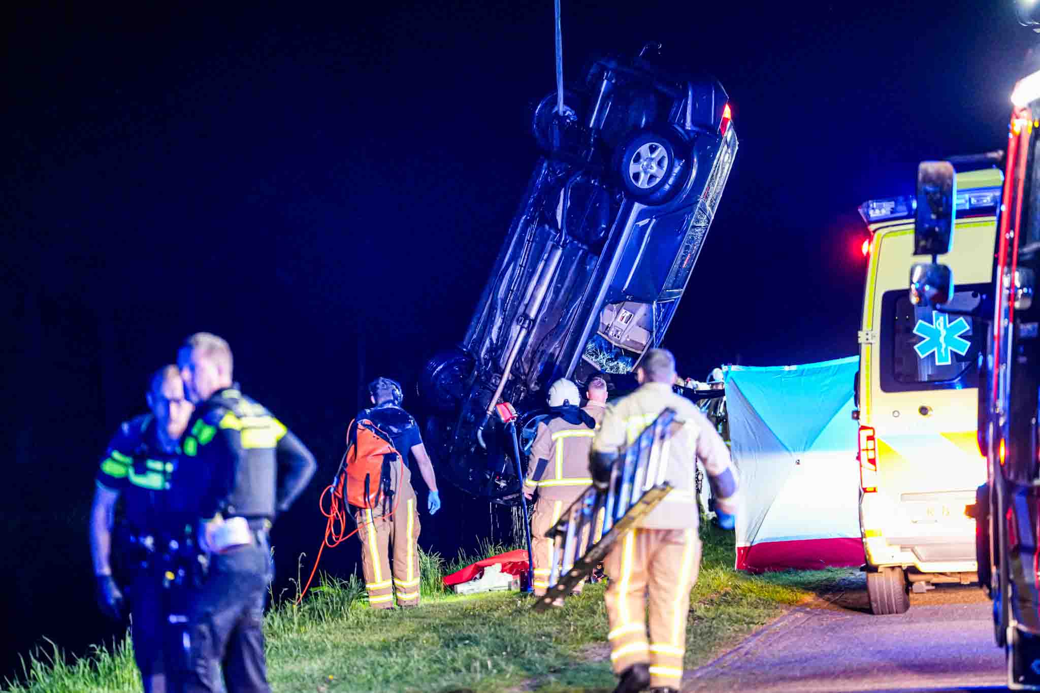 Auto op de kop in kanaal, bestuurder zwaargewond