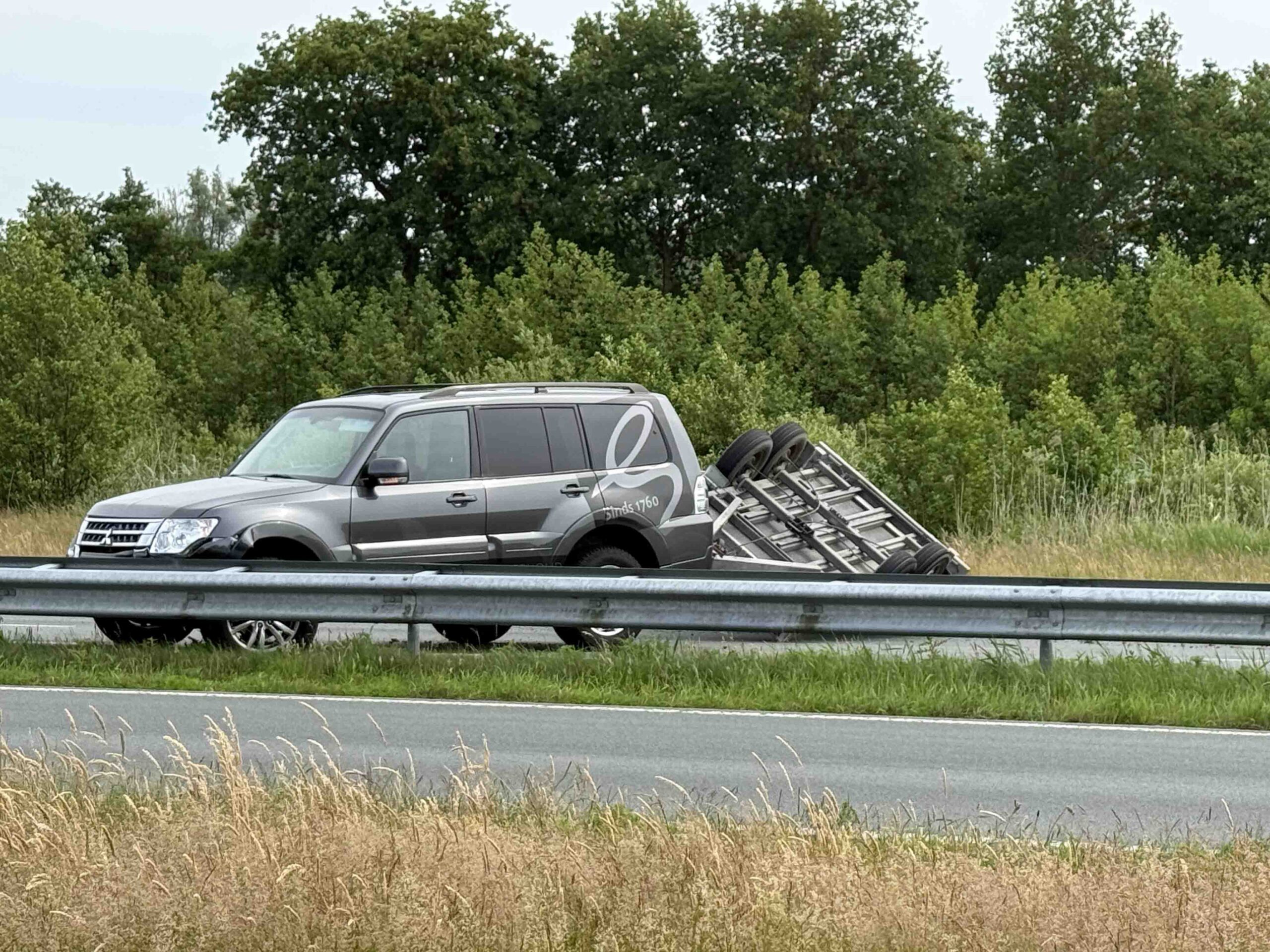 Aanhanger met hoogwerker gekanteld, weg volledig afgesloten