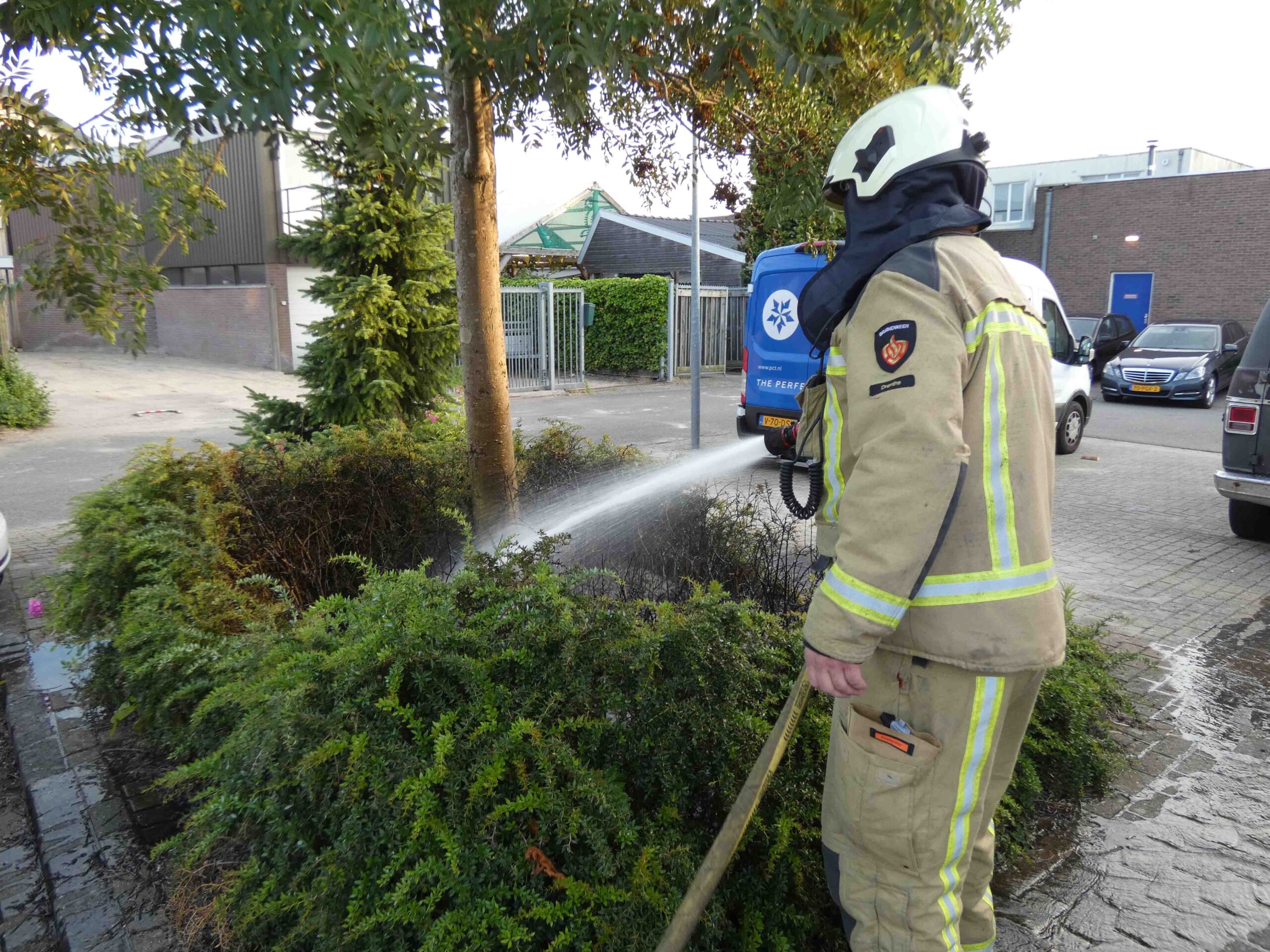 Brand in struiken achter winkel snel geblust door omstanders