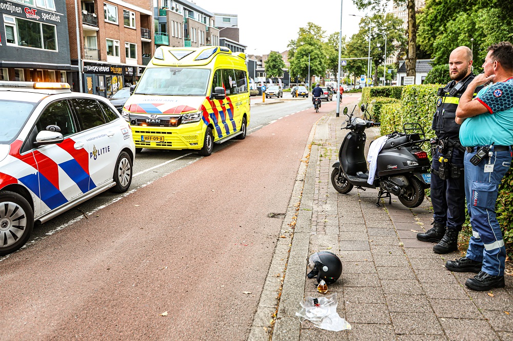 Meisje op scooter komt tegen val door losliggende steen