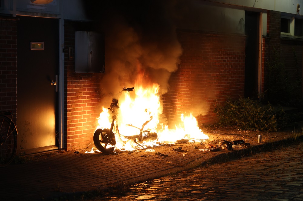 Scooter vliegt in brand tegen gevel