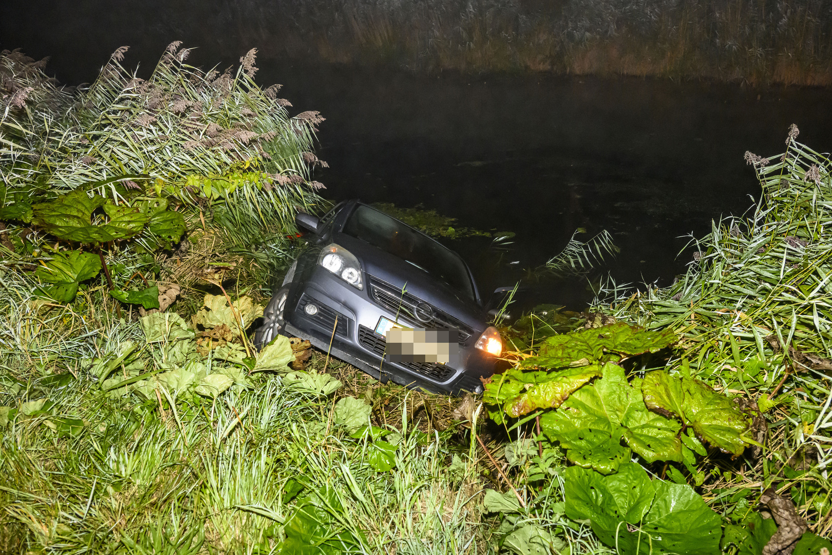 Vrouw rijdt met auto het water in tijdens keren