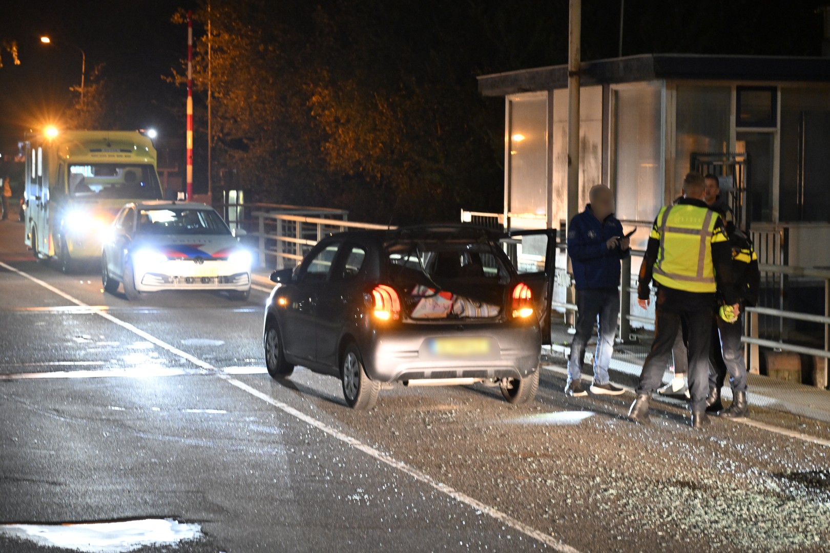 Drie voertuigen komen met elkaar in botsing, weg bezaaid met glas