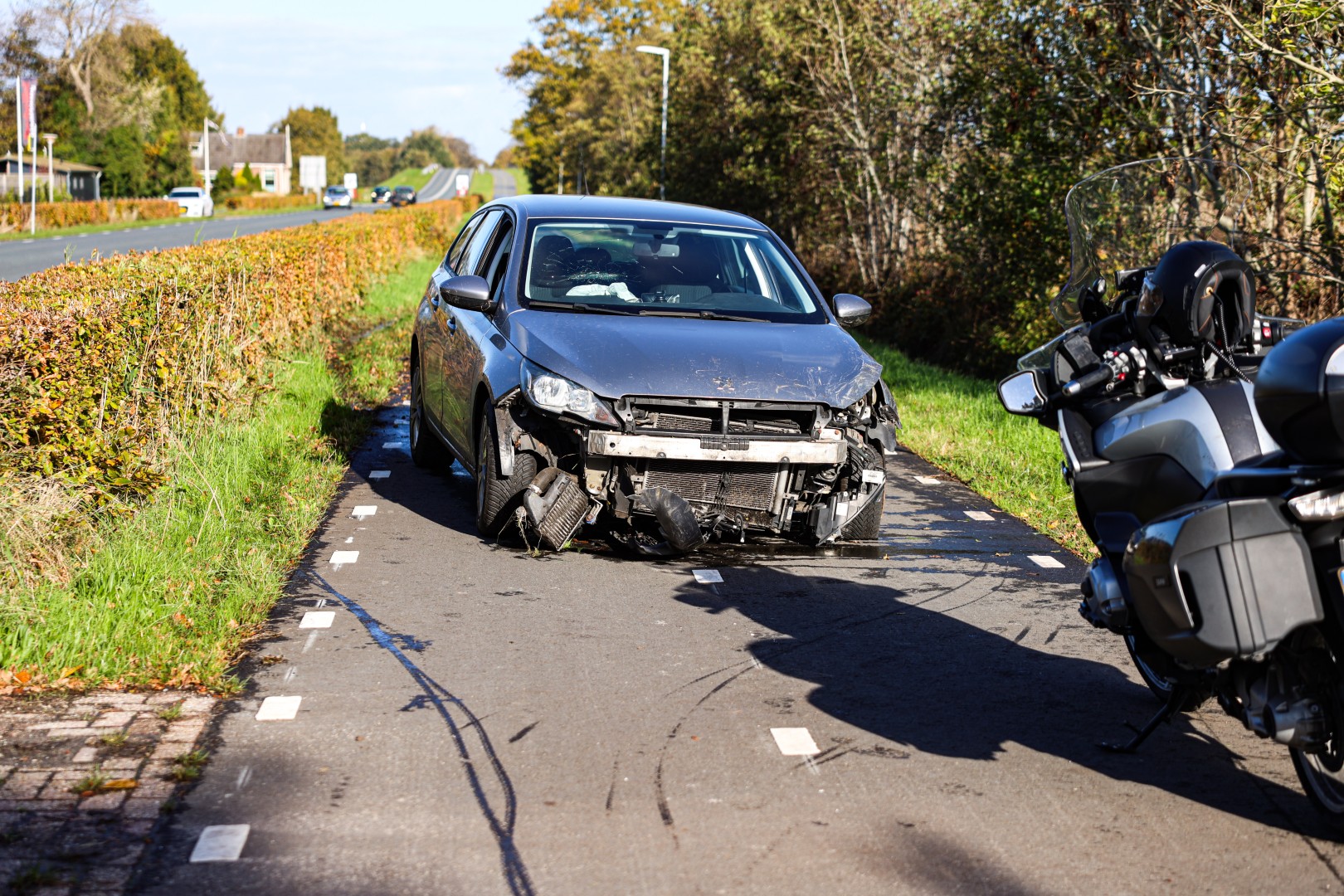 Auto rijdt door heg na uitwijkmanoeuvre