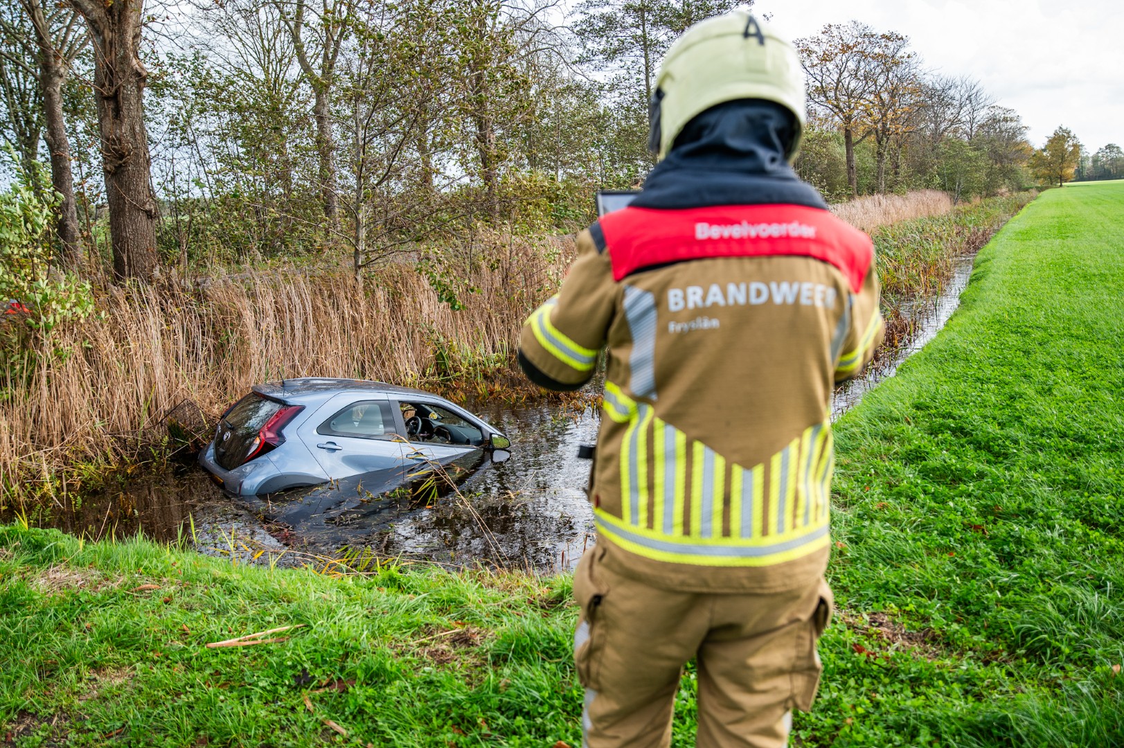 Auto belandt in sloot, twee inzittenden door brandweer uit voertuig gehaald
