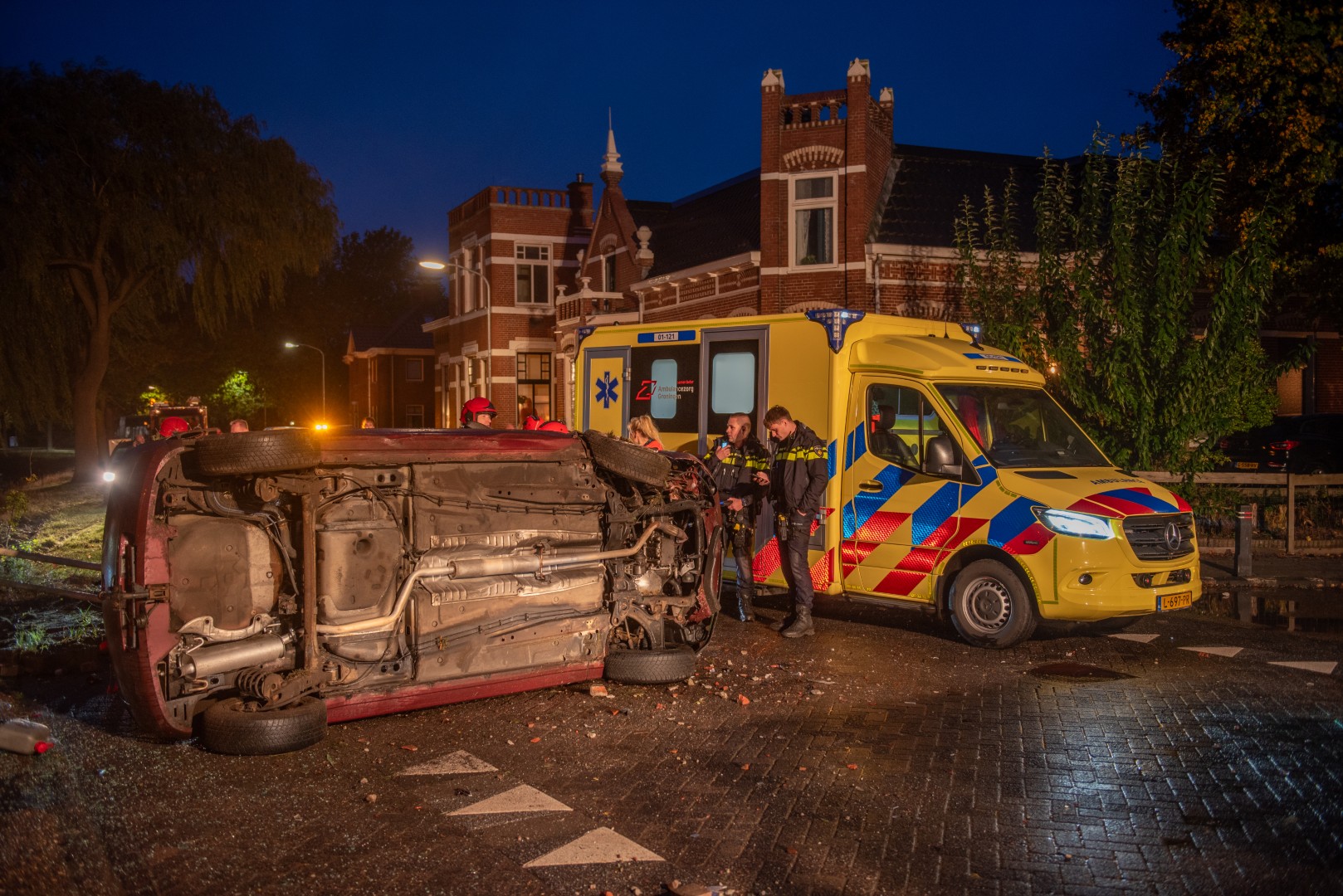 Auto botst tegen brug en belandt op zijkant