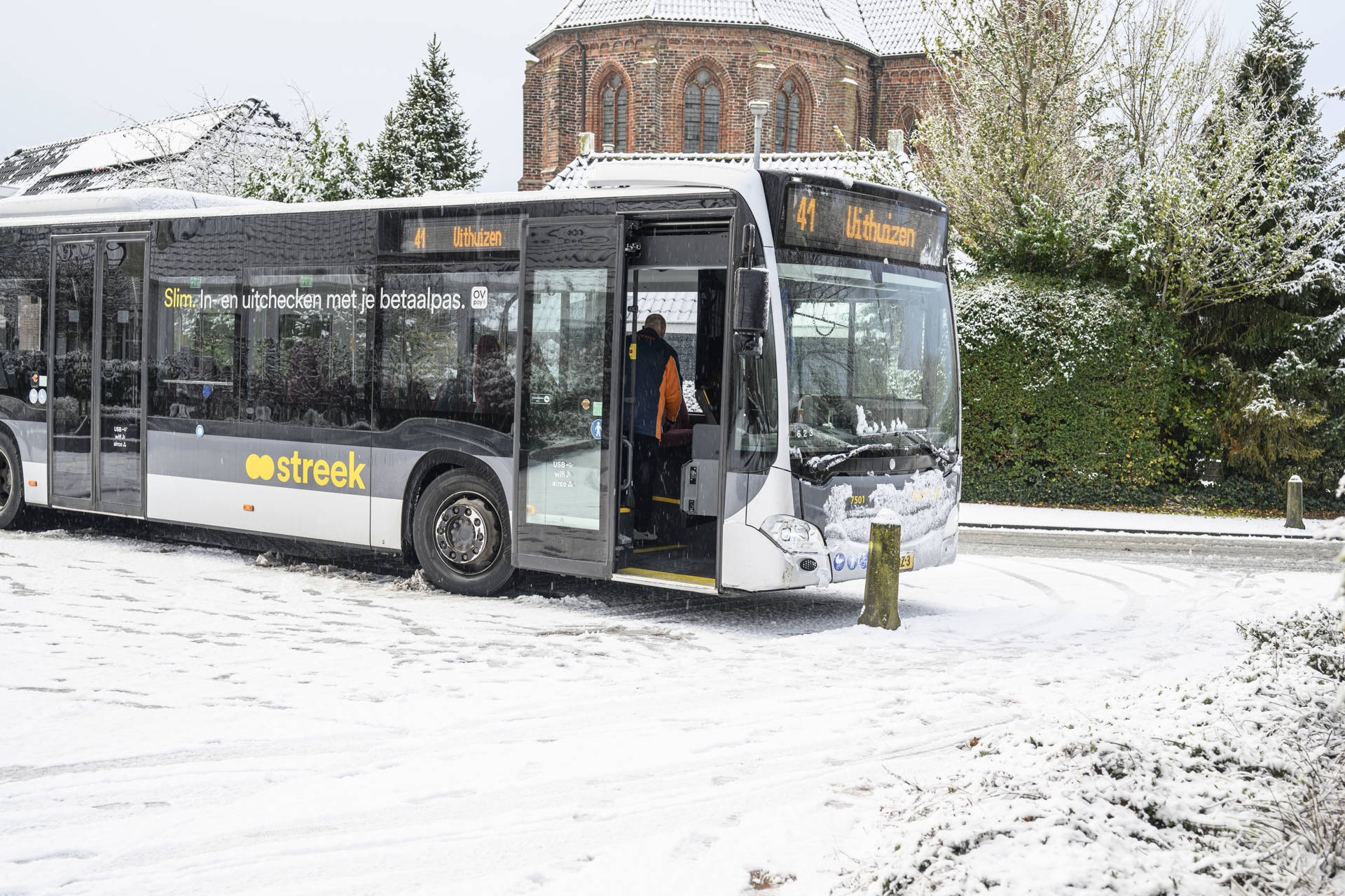 Lijnbus glijdt door en mist de bocht in tegen paaltje