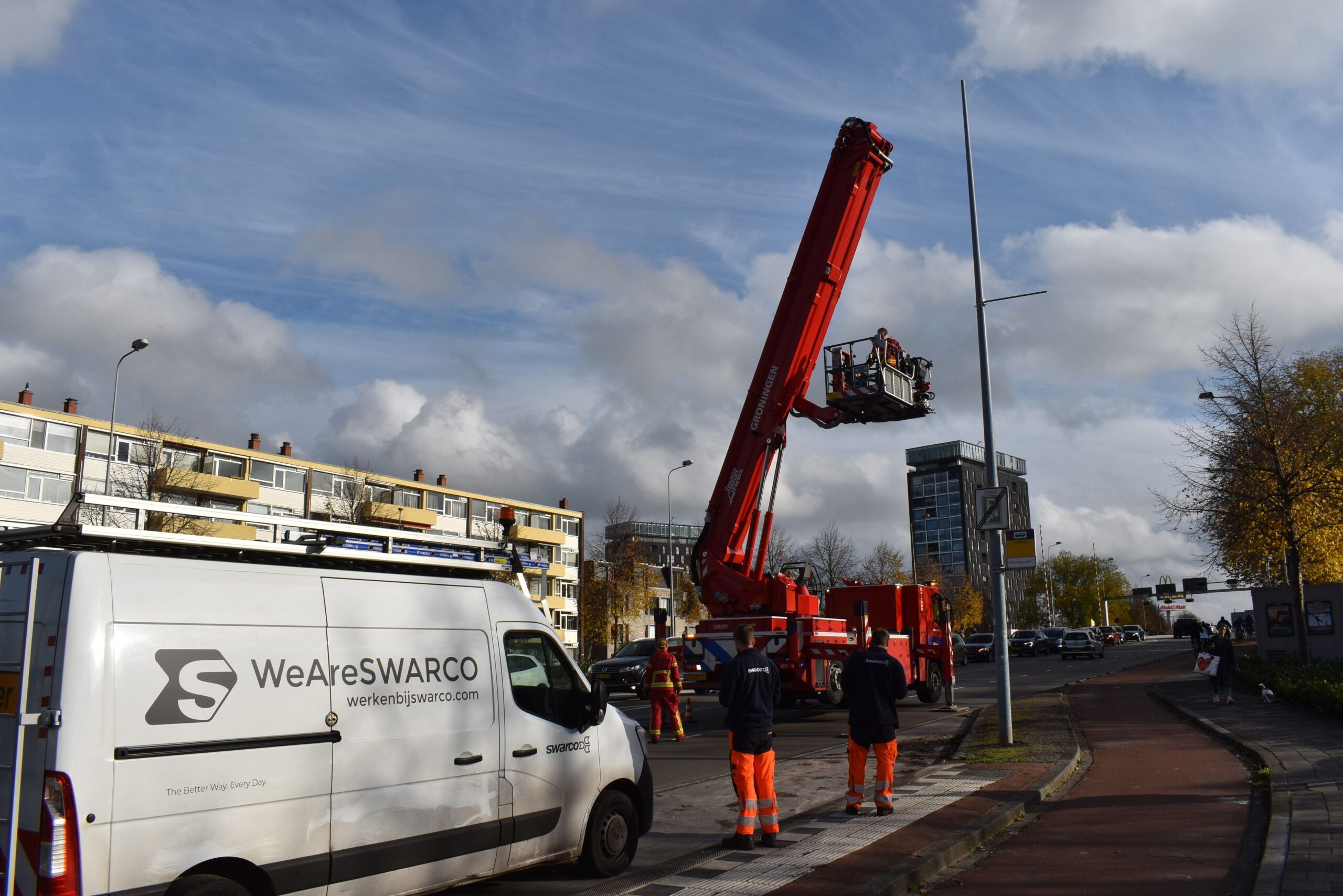 Brandweer verwijderd gevaarlijk los hangende lamp van lantaarnpaal