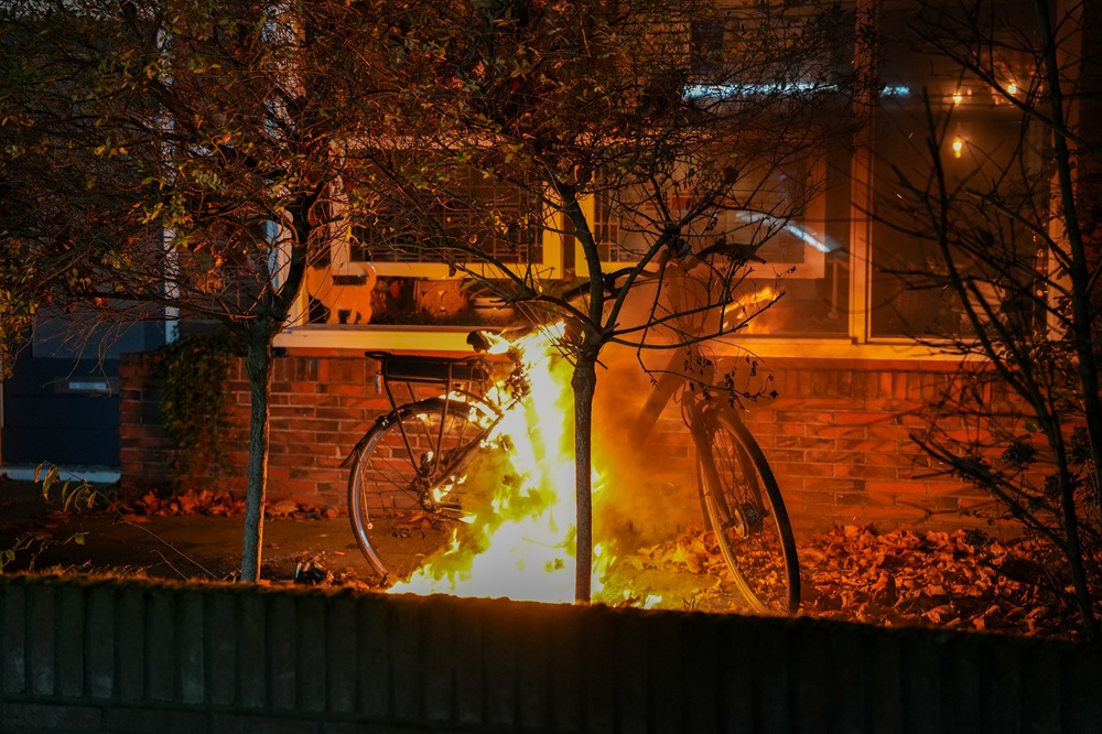 Elektrische fiets in lichterlaaie in voortuin van woning