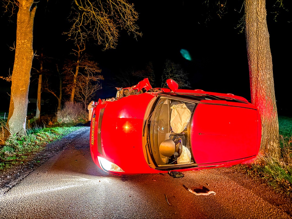 Auto op z’n kant na botsing tegen boom