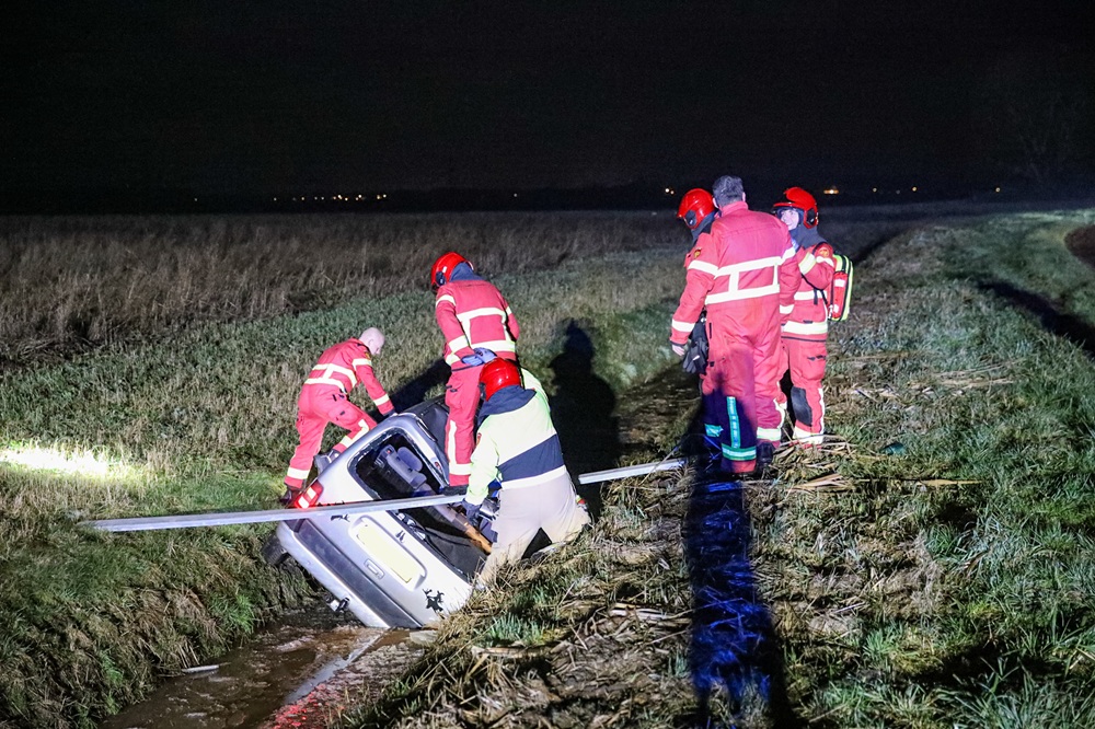 Auto glijdt van spekgladde klinkerweg en belandt in sloot