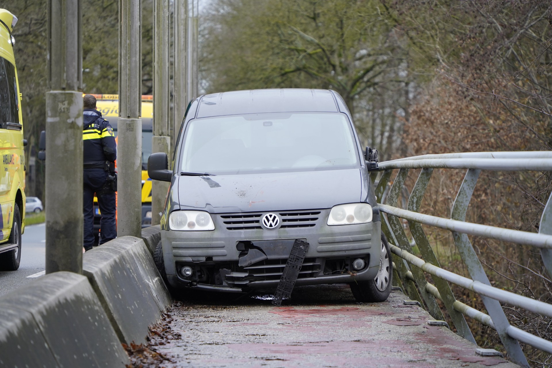 Voertuig vast tussen brugleuning en afscheiding
