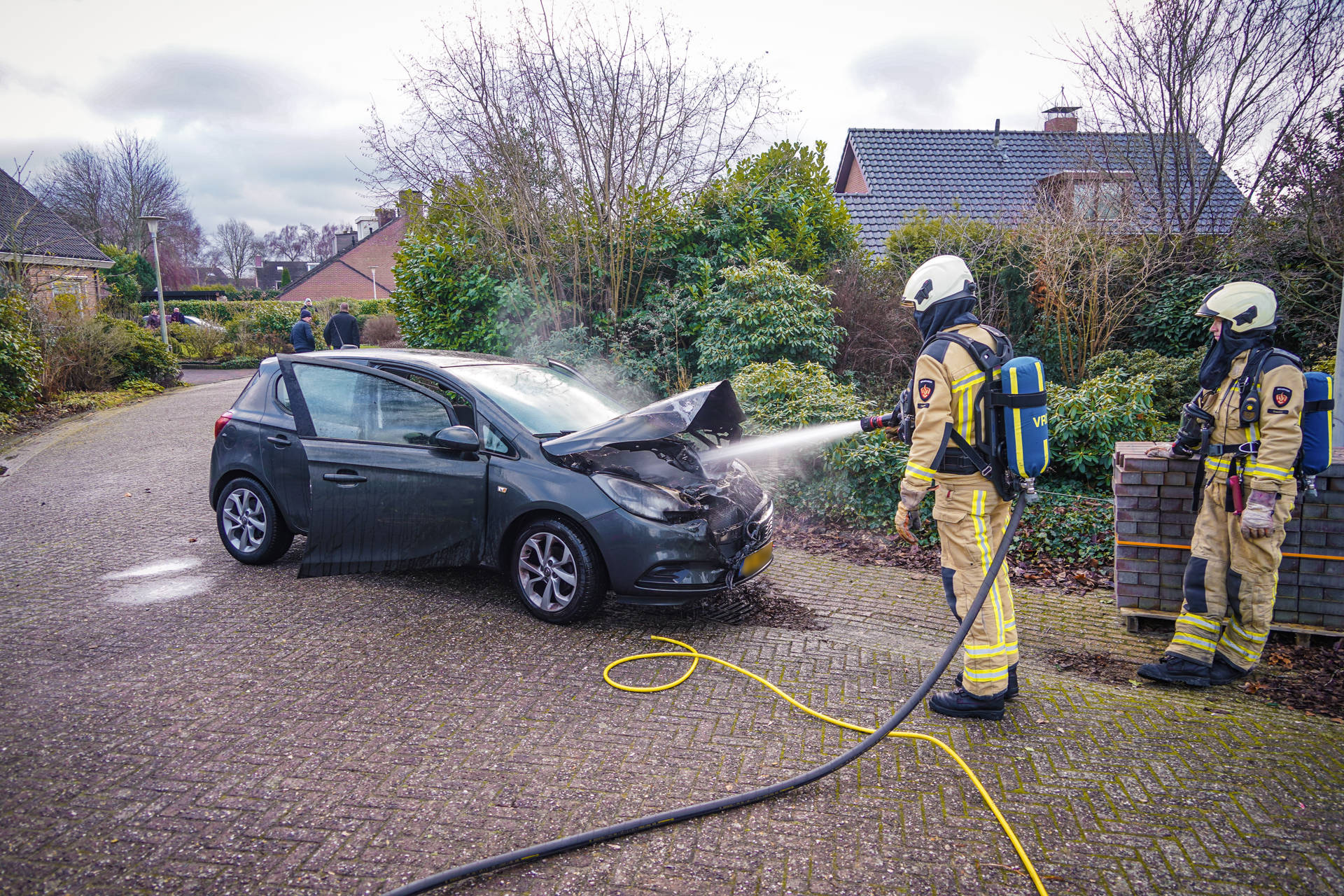 Omstanders blussen autobrand, brandweer doet nacontrole