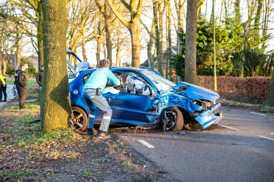Auto botst tegen boom, bestuurder nagekeken door ambulance