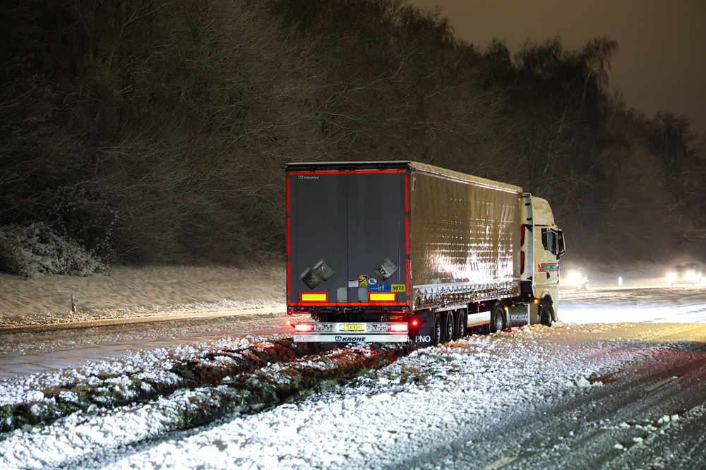 Vrachtwagen glijdt van de weg en komt vast te zitten in berm