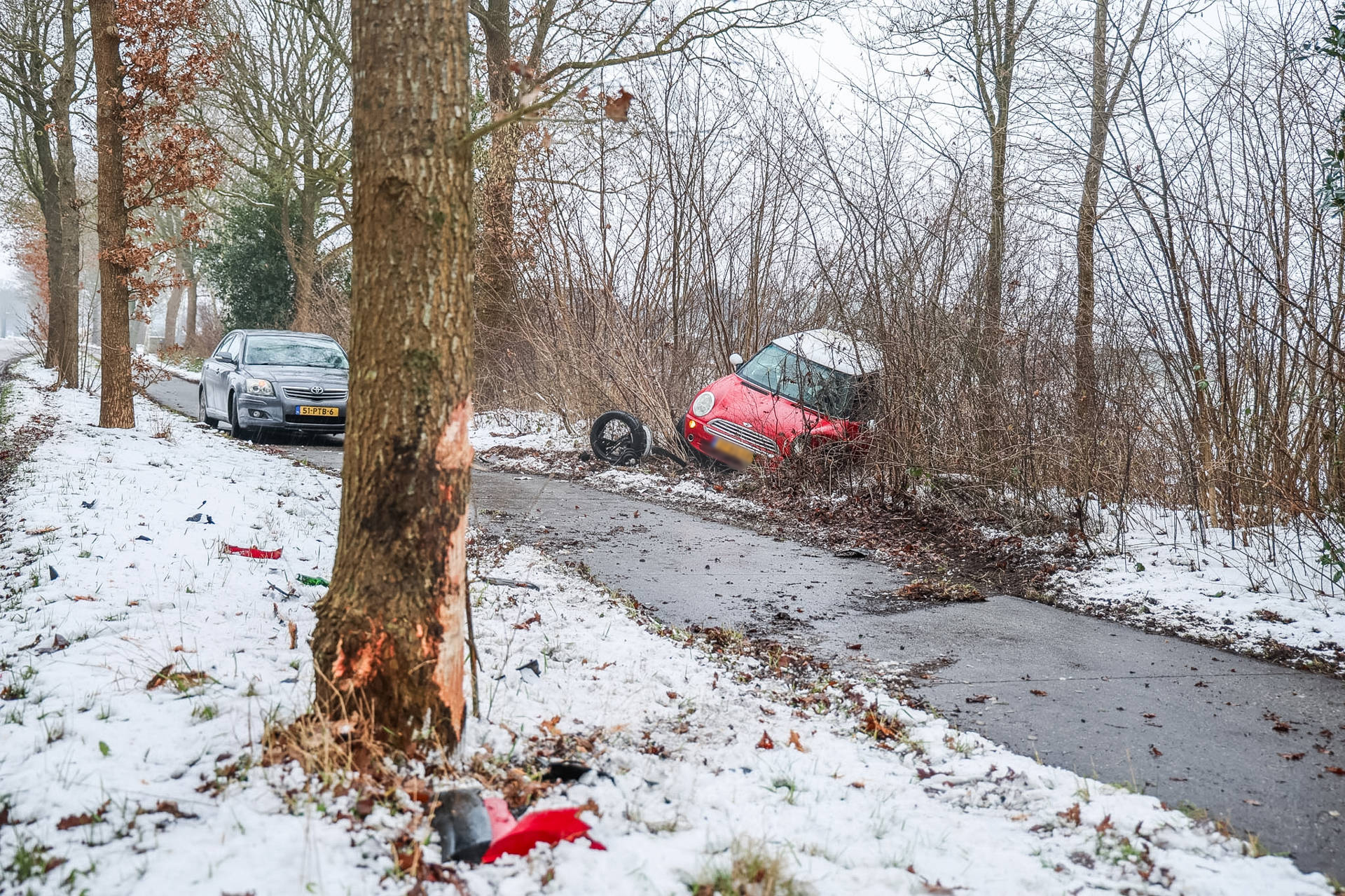 Auto raakt door gladheid van de weg en belandt in bosjes