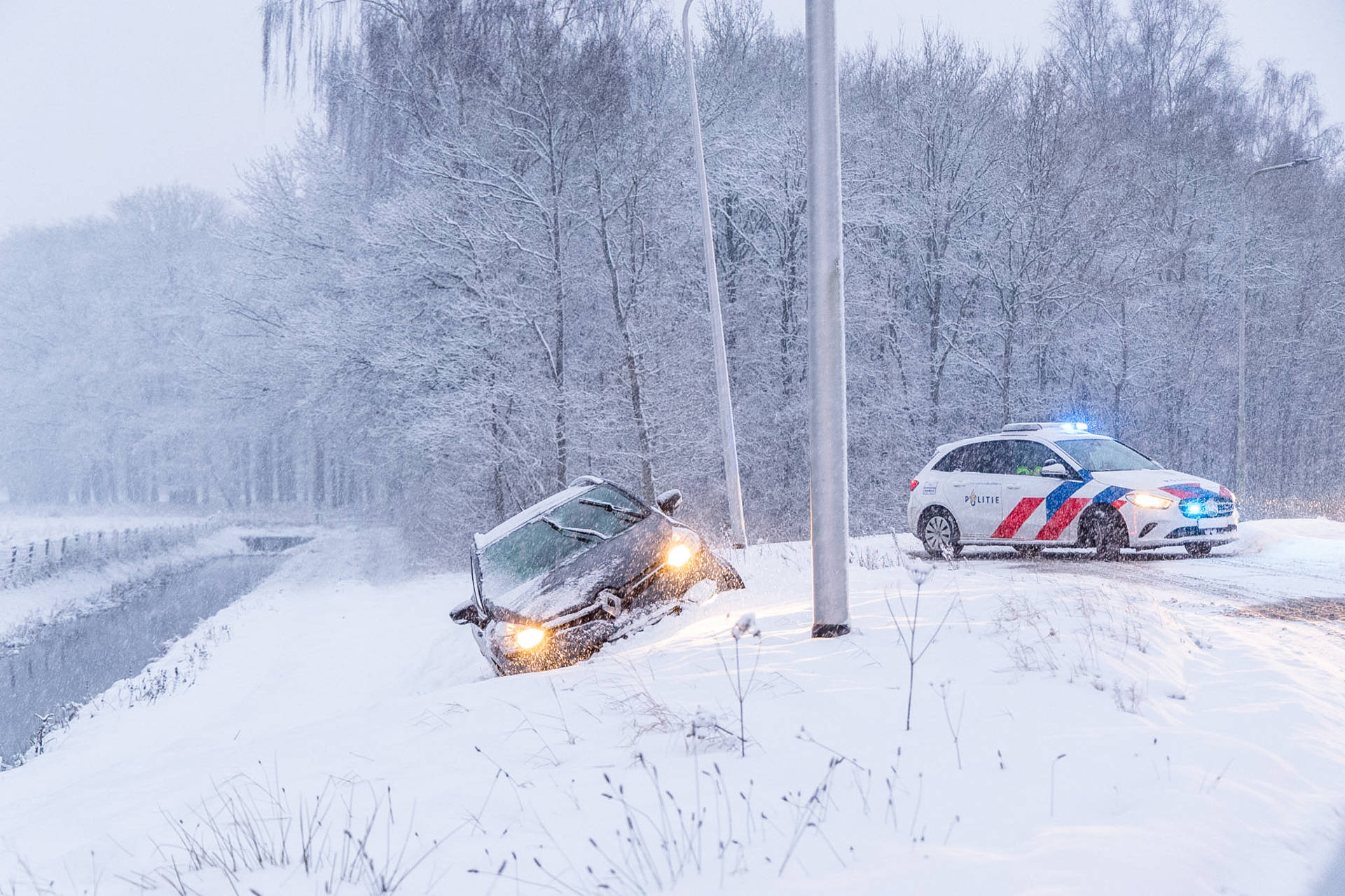 Meerdere auto’s glijden van de weg door sneeuw