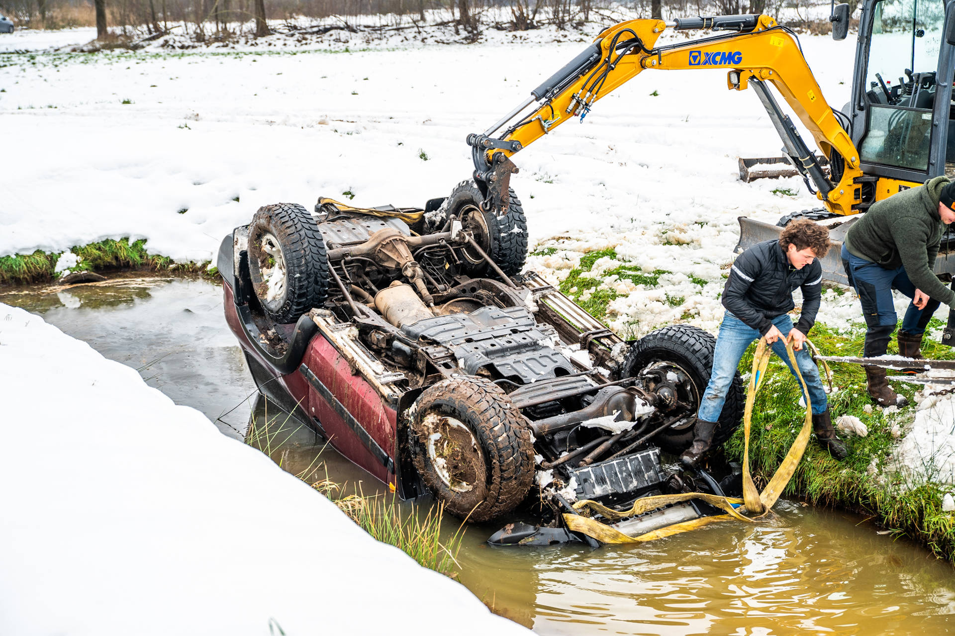 Auto op de kop in sloot, omstanders schieten te hulp