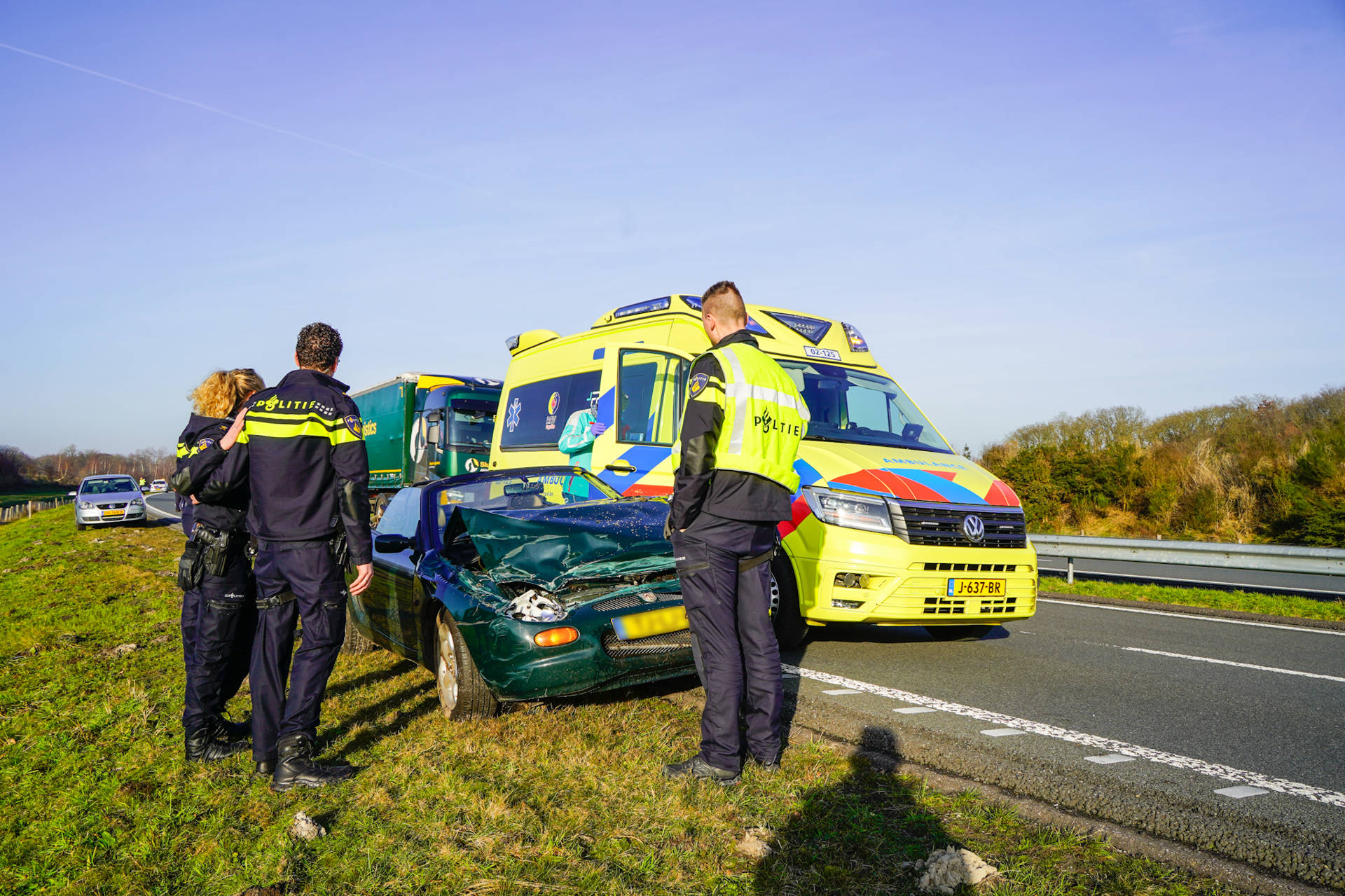 Cabrio botst tegen vangrail, bestuurder onderzocht door ambulance