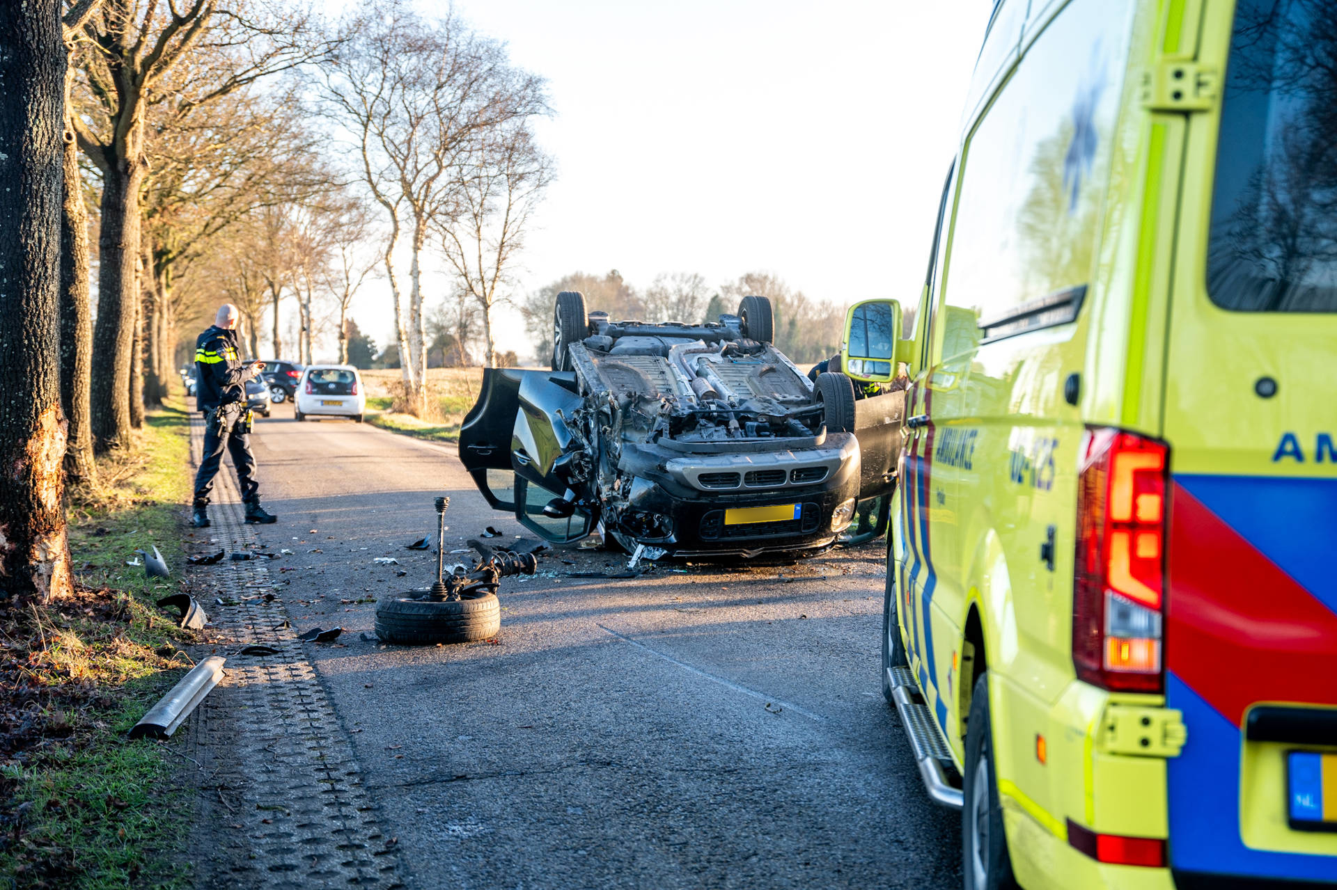 Auto raakt boom en beland op zijn dak