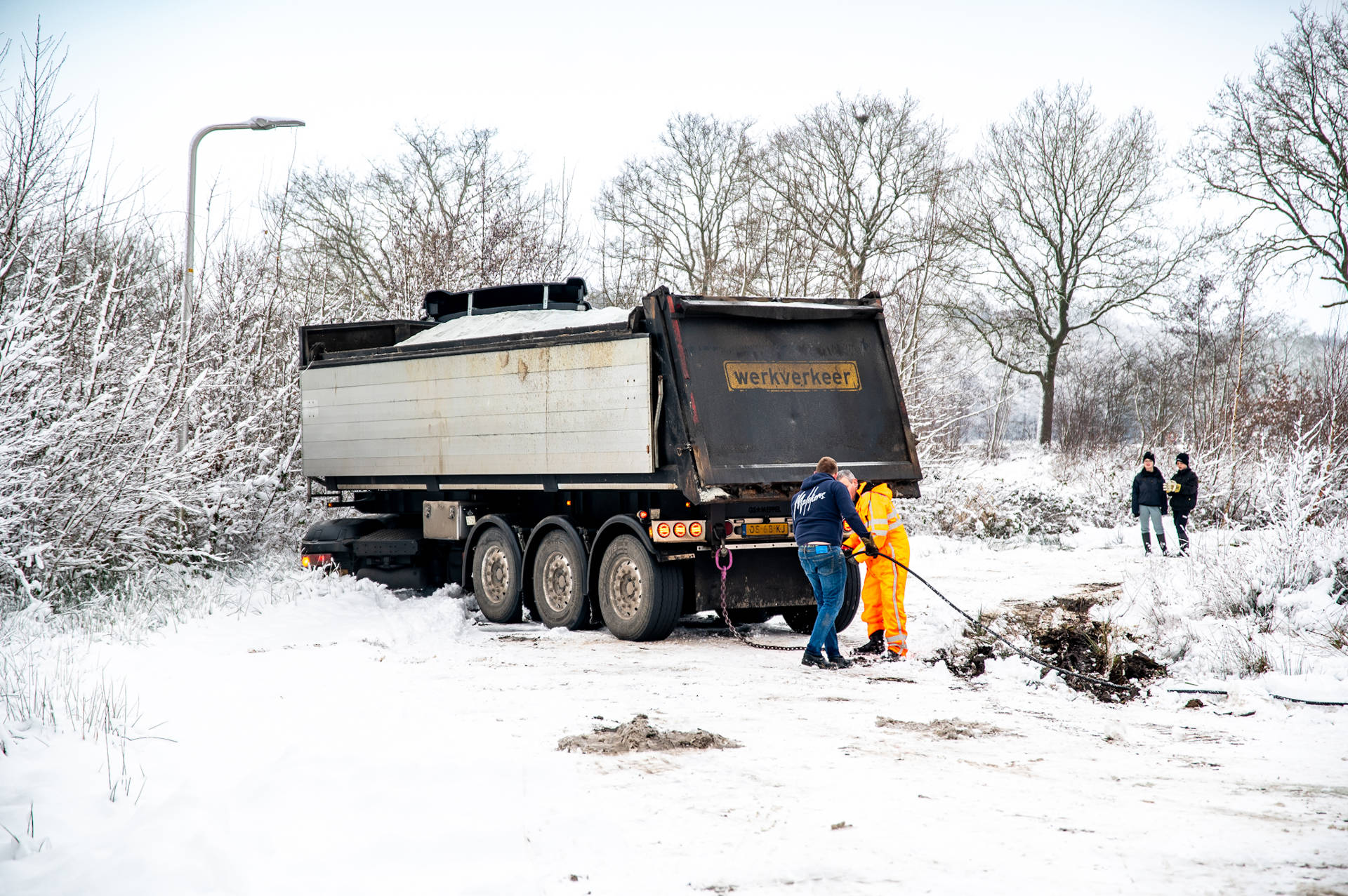 Vrachtwagen met strooizout glijdt door gladheid van de weg