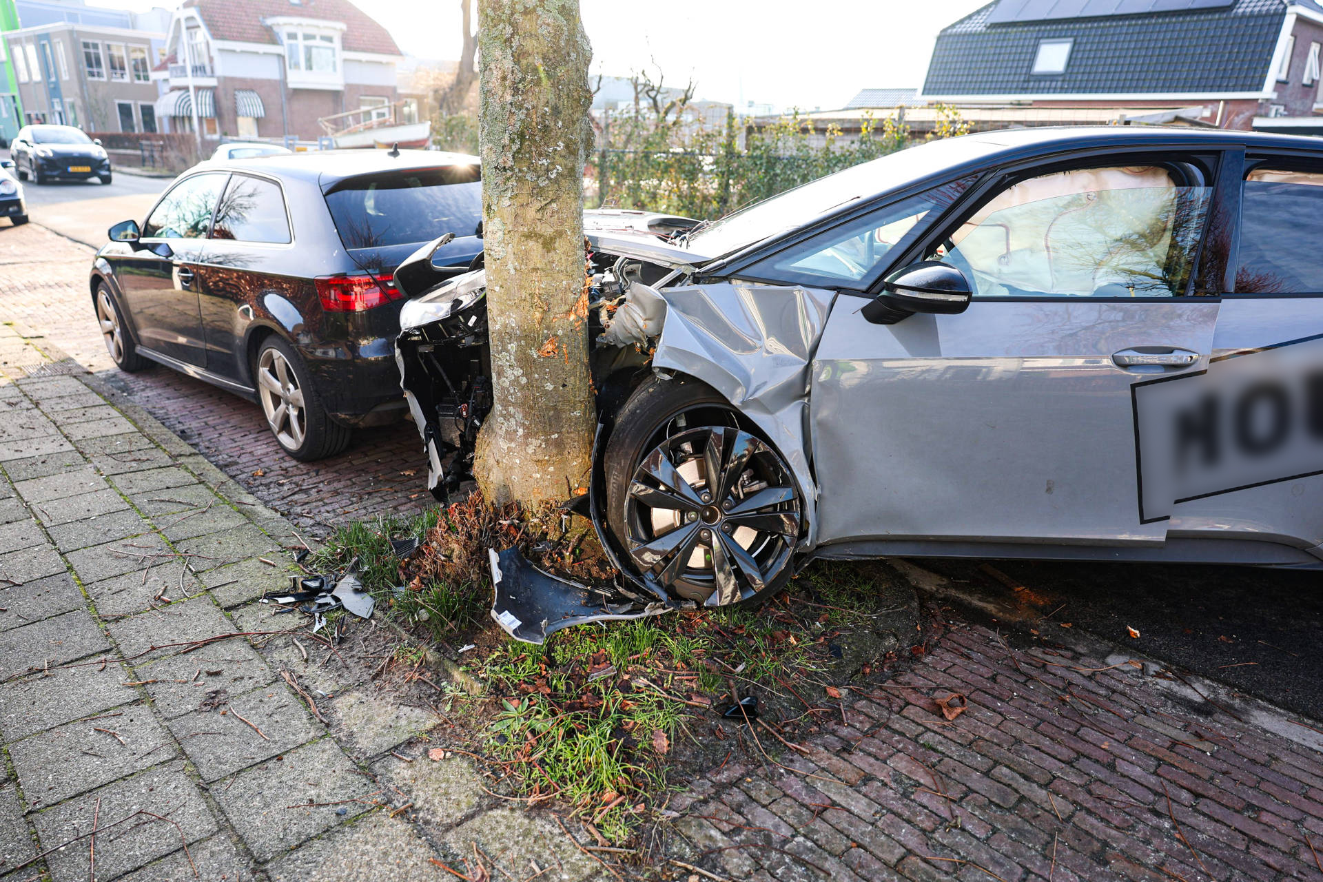 Automobilist botst tegen boom en raakt geparkeerde auto