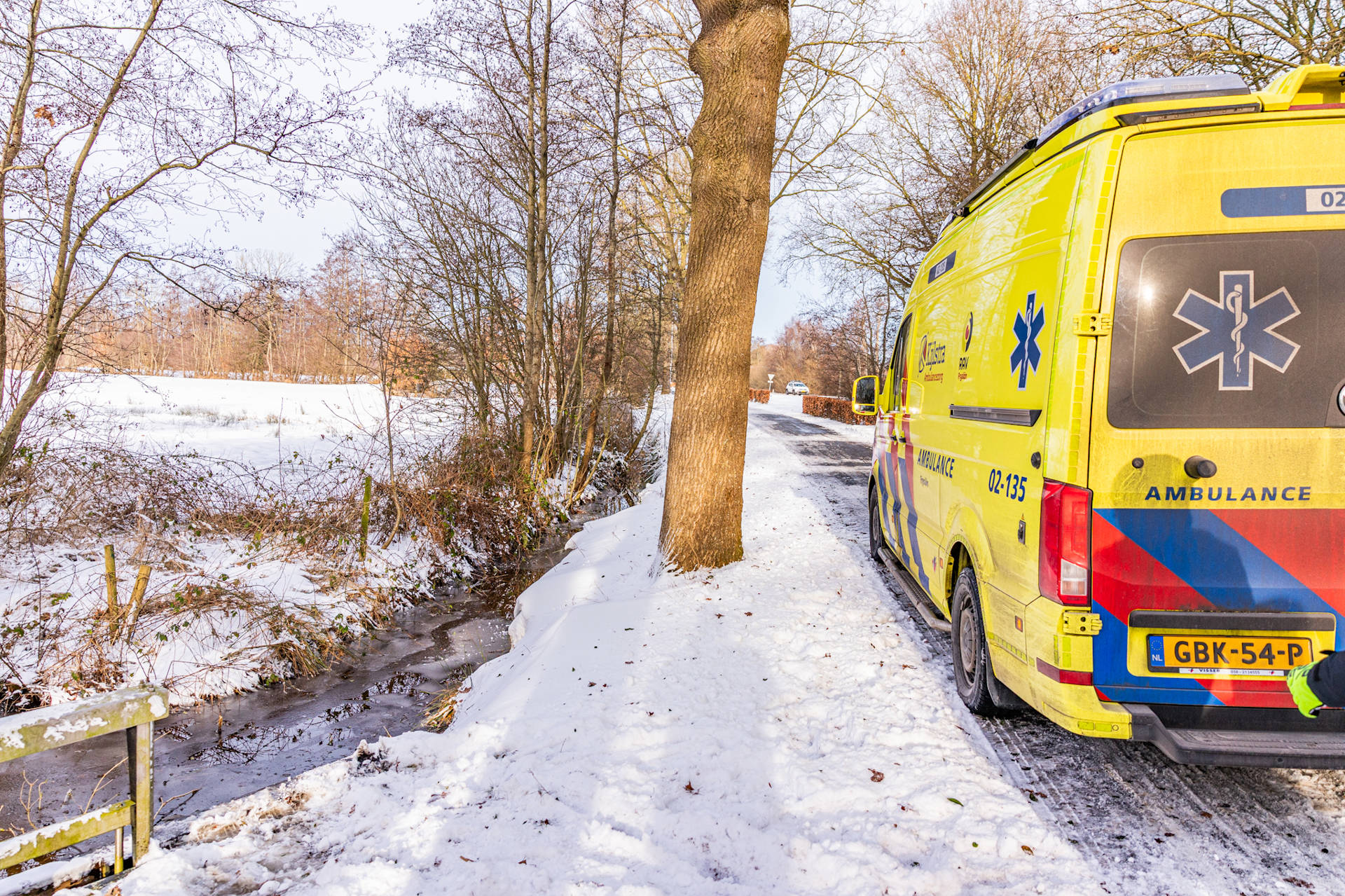 Man door omstanders uit ijskoud water gered langs fietspad