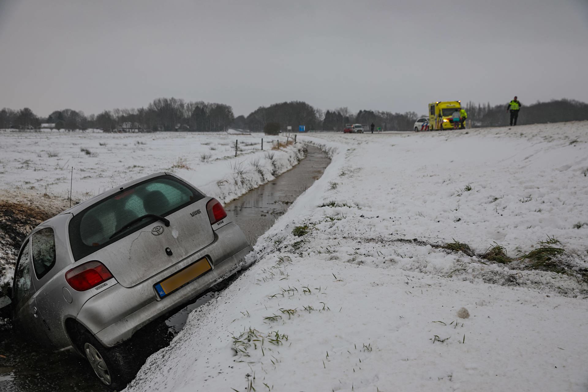 Omstanders halen bestuurder uit te water geraakte auto
