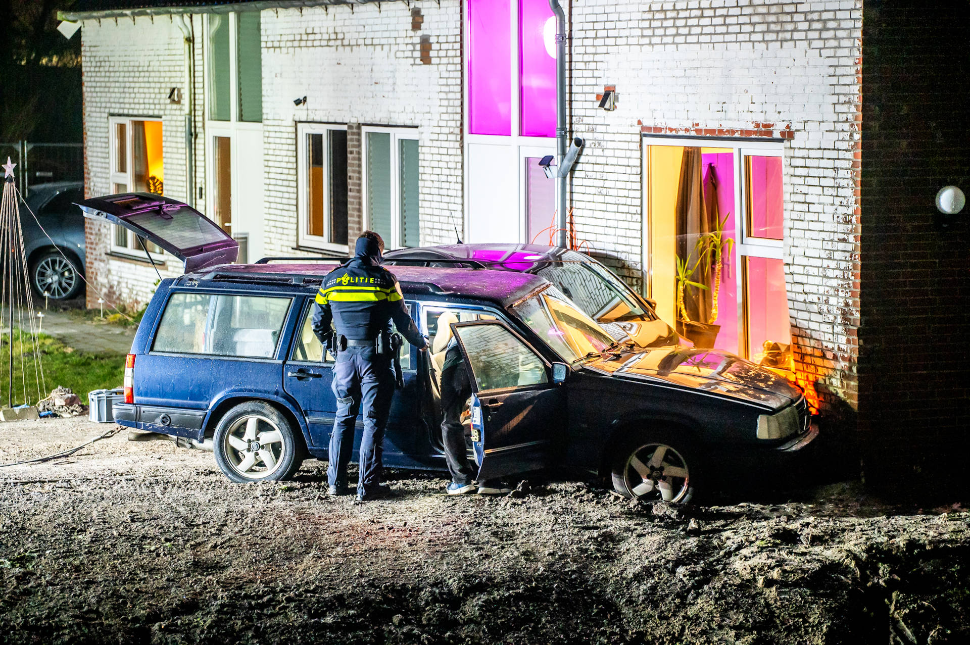 Twee voertuigen belanden tegen woning, bestuurder gevlucht