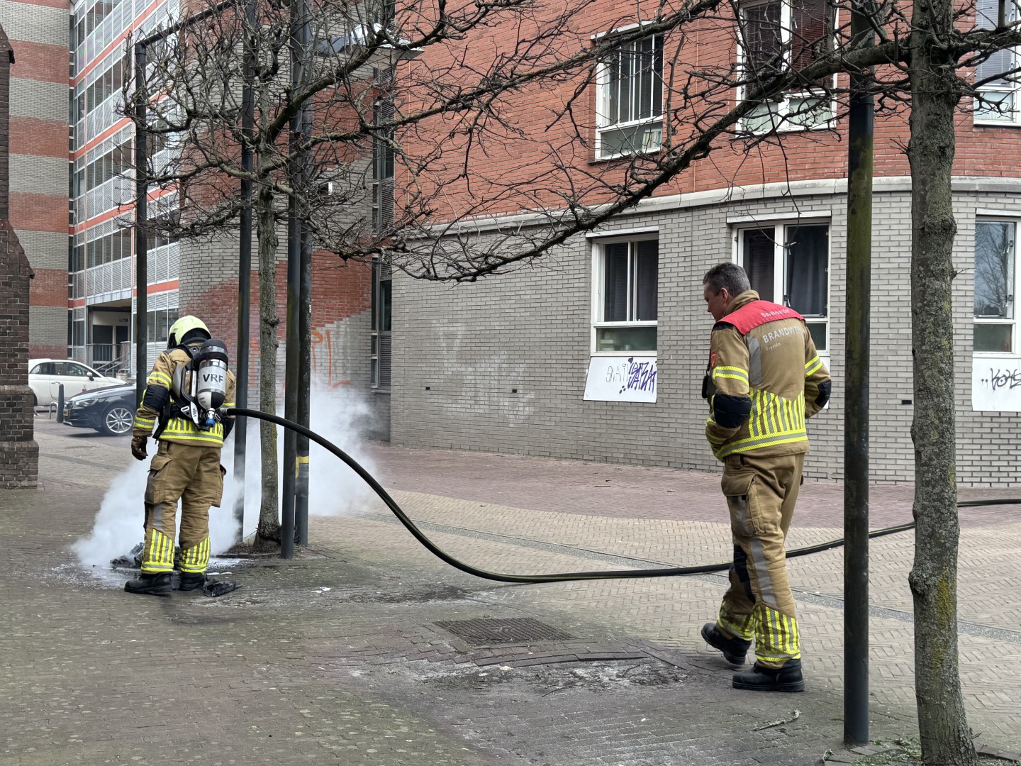 Brandweer blust brandend elektrisch apparaat, rook activeert brandalarmen