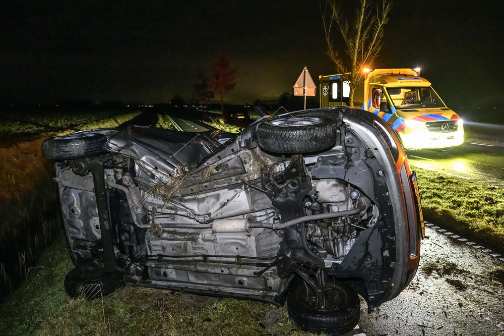 Auto op z’n kant na botsing tegen boom