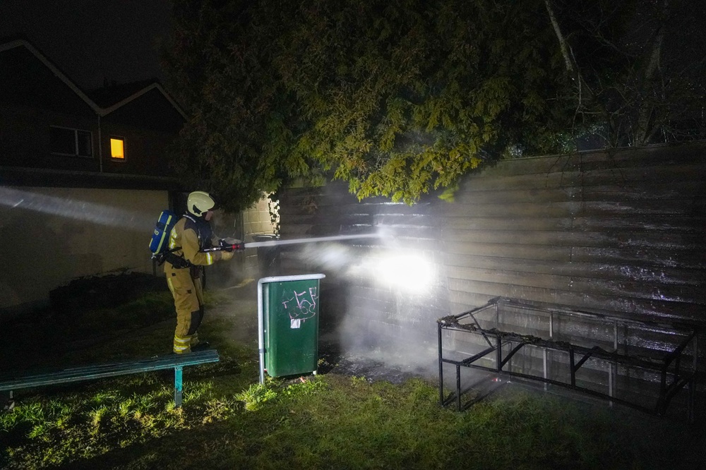 Bankstel en schutting in brand